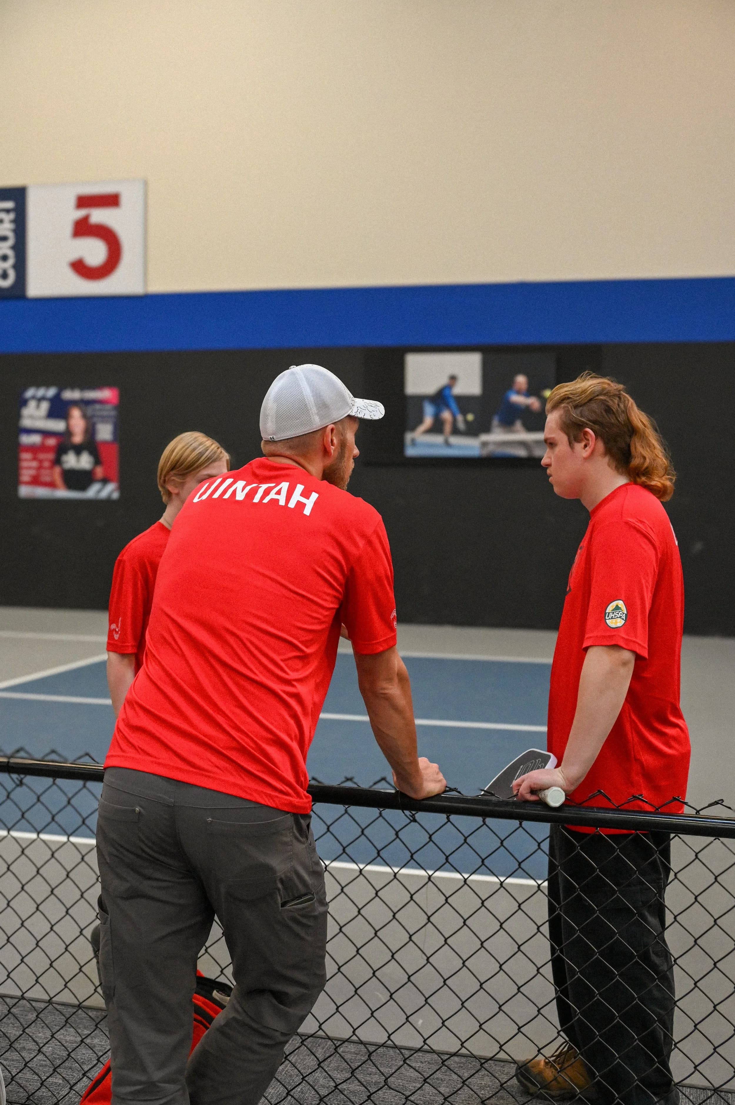 UHSPA coach working with high school pickleball players on court